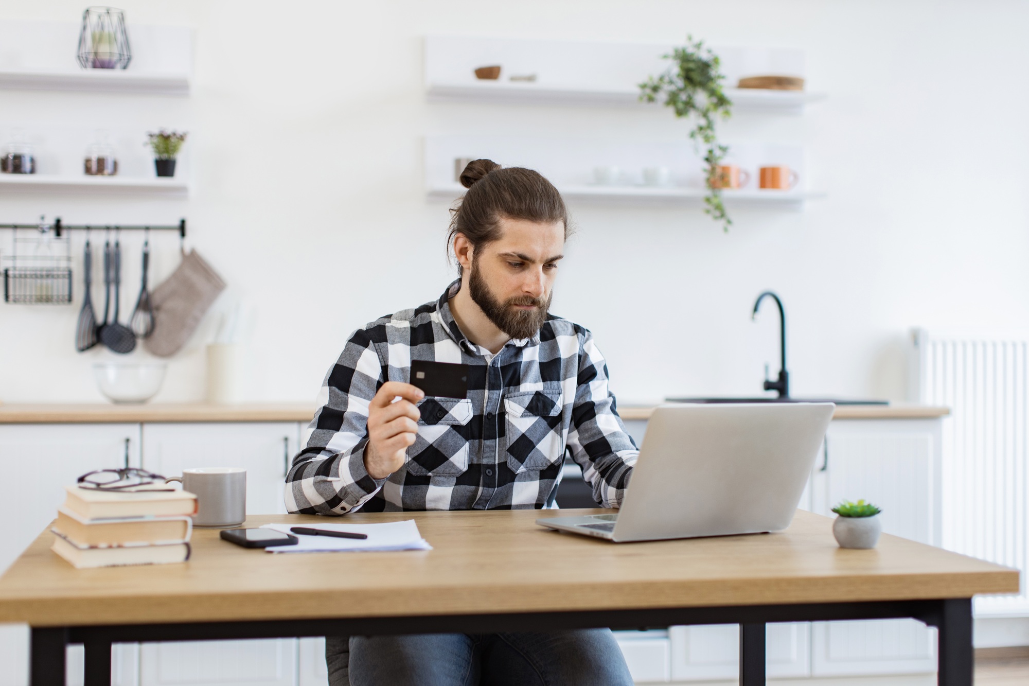 Happy gentleman doing online banking transaction while working remotely.